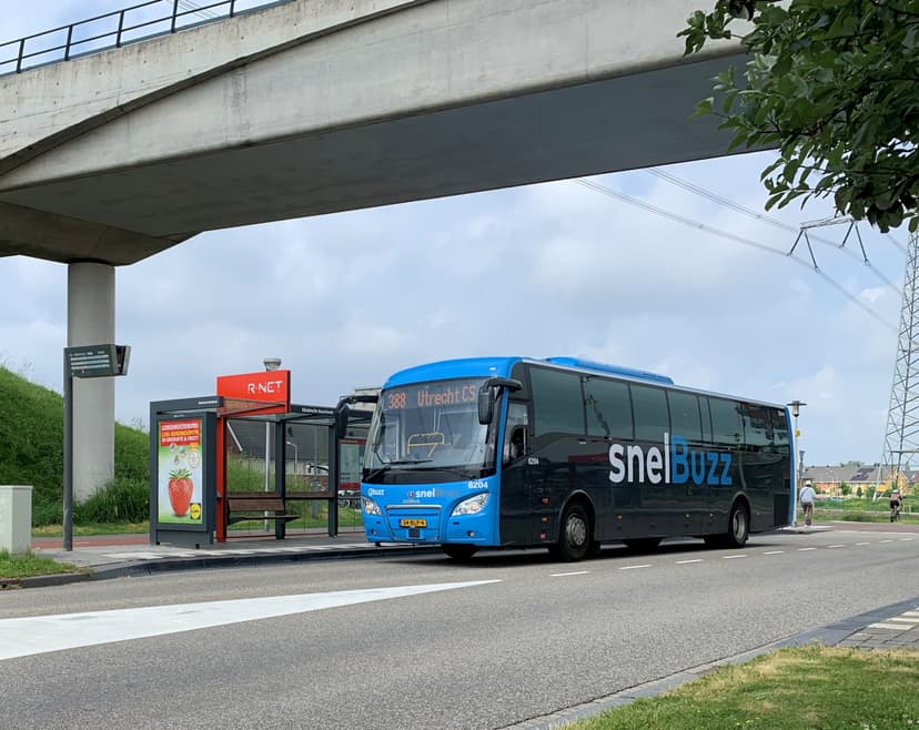 Een SnelBuzz staat bij een bushalte onder een viaduct